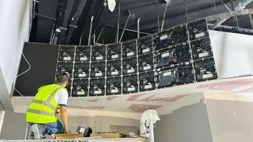 technician installing led screen frame on structure 